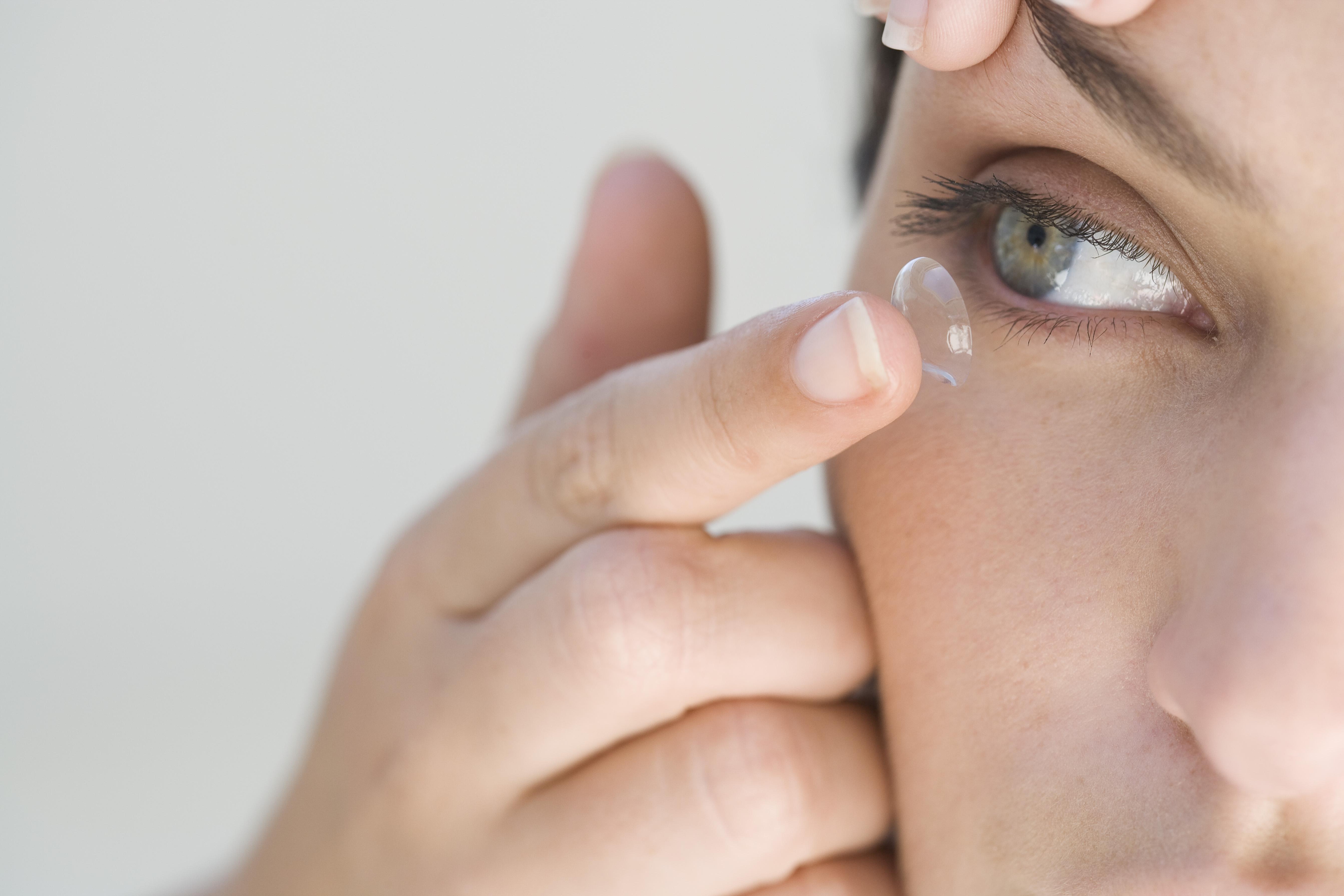 Mujer de ojos verdes poniéndose una lentilla