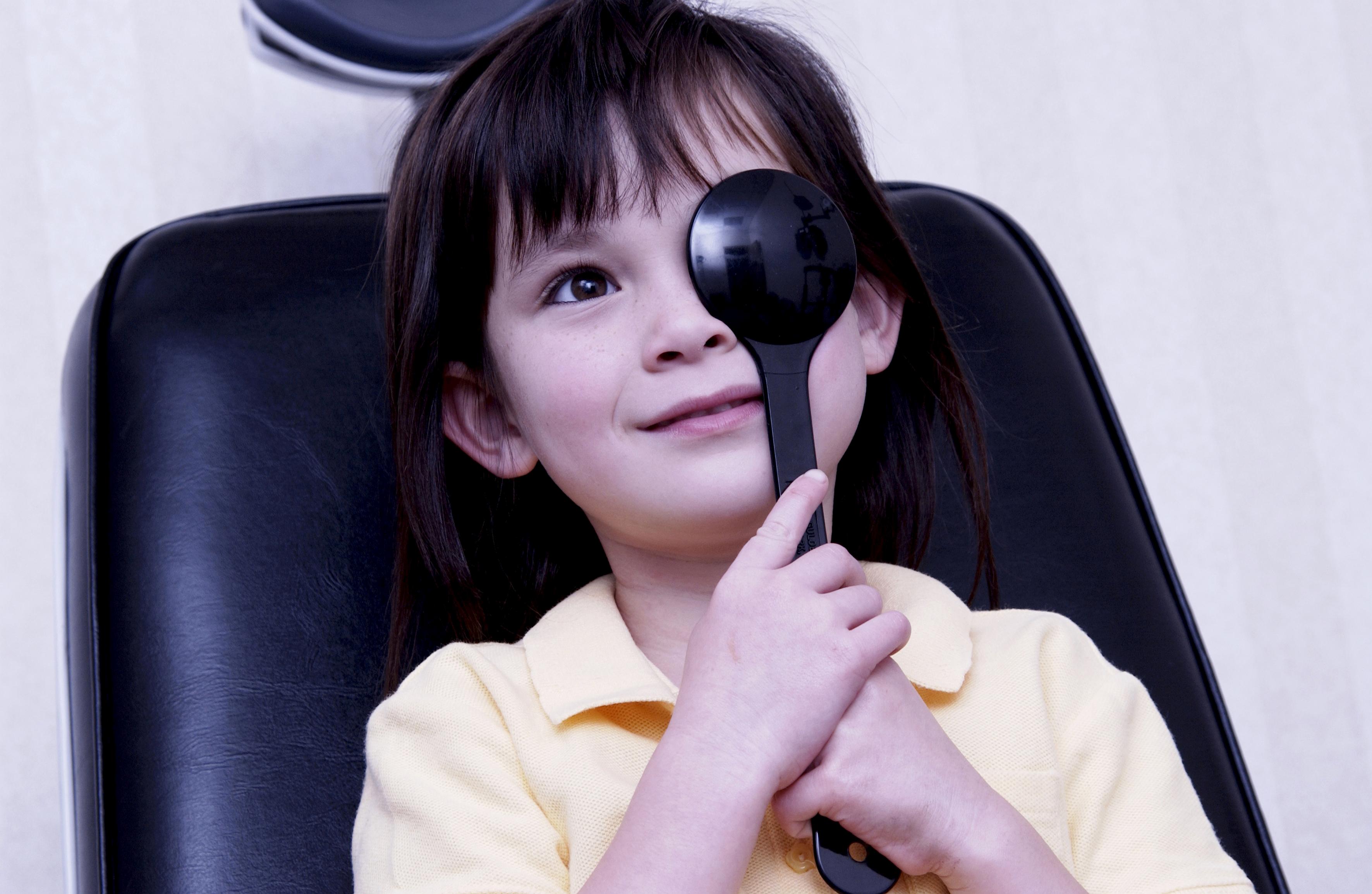 Niño tapándose un ojo durante una revisión oftalmológica