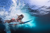 Mujer con tabla de surf en el mar