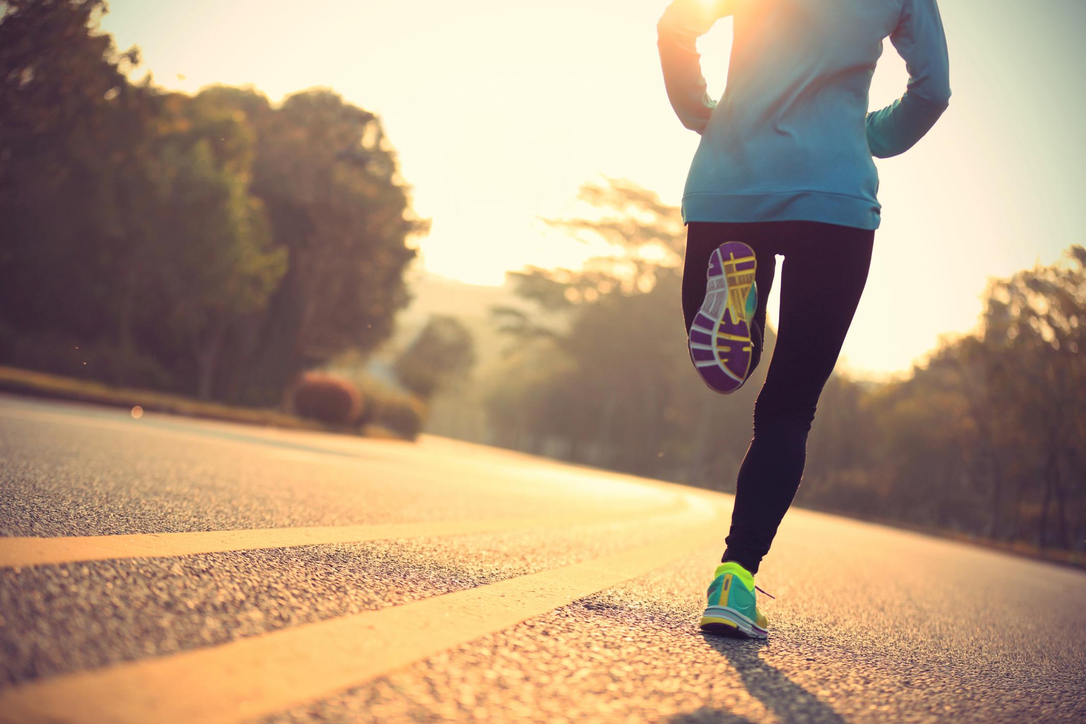 Mujer corriendo de espaldas con zapatillas verdes