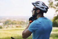 Ciclista con camiseta azul poniéndose el casco