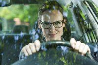 Mujer con gafas conduciendo un coche