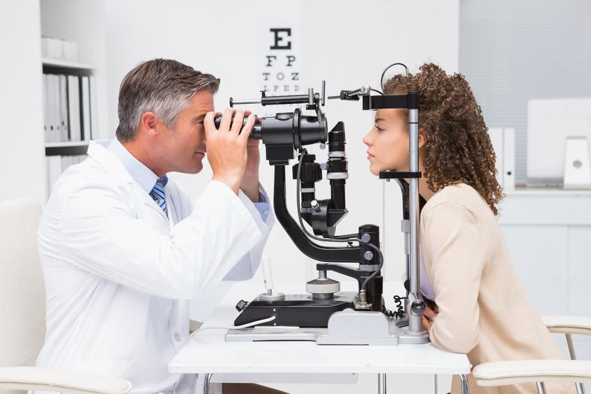 Mujer de pelo rizado en consulta con óptico optometrista
