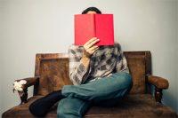 Hombre leyendo un libro rojo