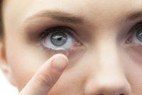 Mujer de ojos azules poniéndose una lente de contacto