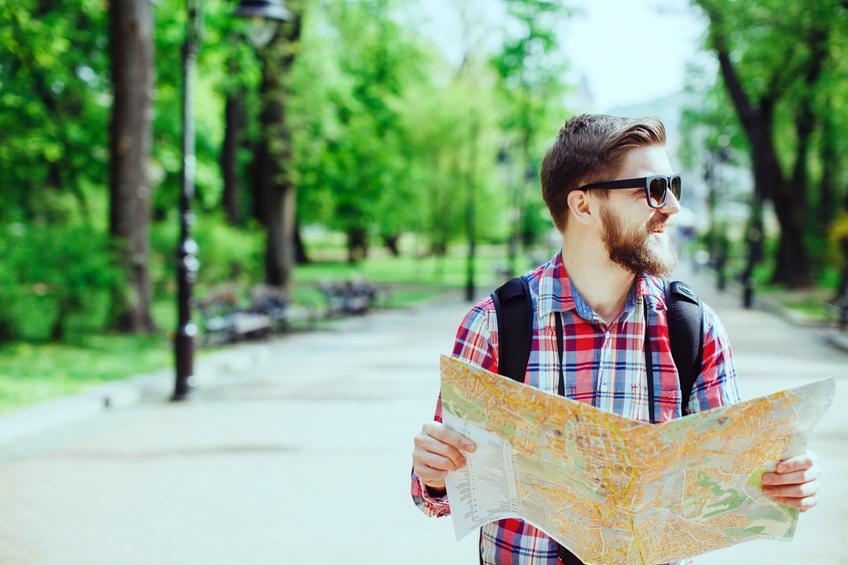 tourist with beard laughing and holding a map