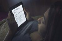 Mujer leyendo un libro electrónico a oscuras