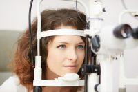 Mujer con pelo rizado y ojos azules se hace una prueba oftalmológica