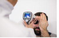 Hombre con barba haciéndose una retinografía