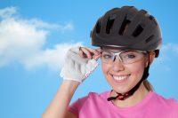 Mujer ciclista con casco, gafas y camiseta rosa