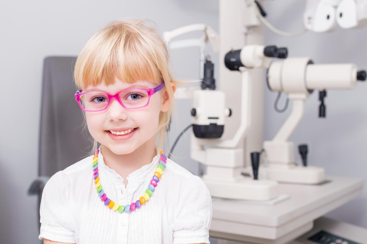 Niña rubia con gafas rosas en una consulta de oftalmología