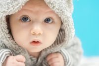 Bebé de ojos azules mira a la cámara