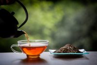 Taza de té, tetera y hojas de té