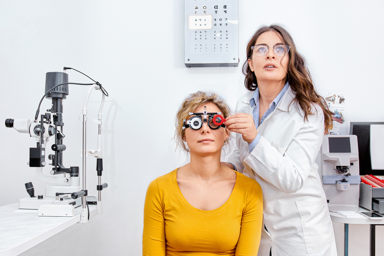 Óptico midiendo la refracción ocular de una paciente