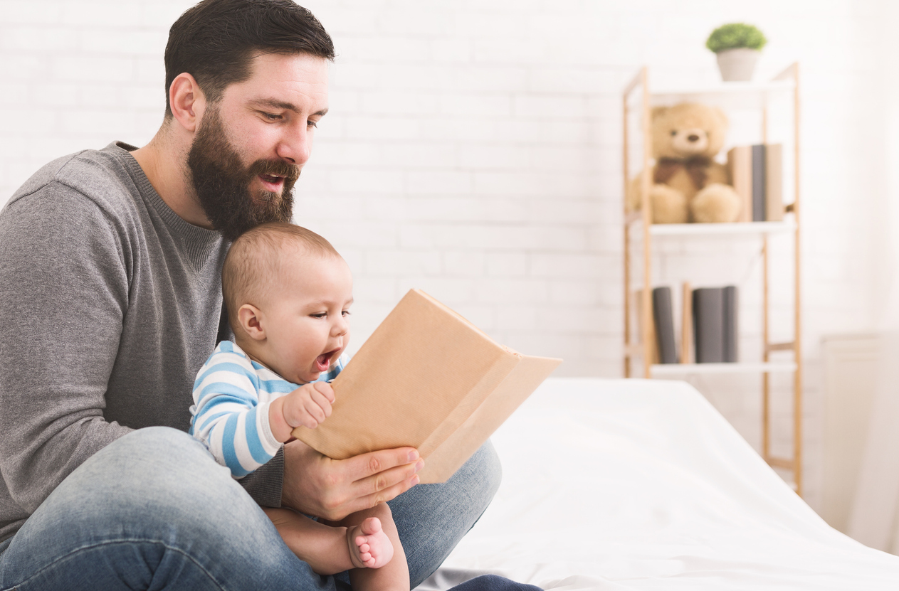 Padre mirando un libro con un bebé