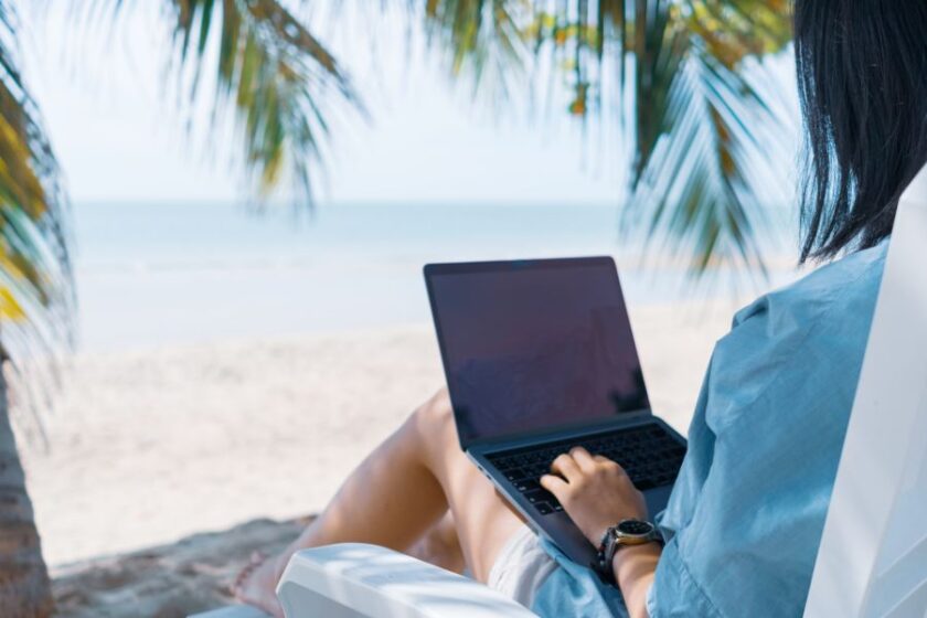 Mujer usando el ordenador mientras está en la playa