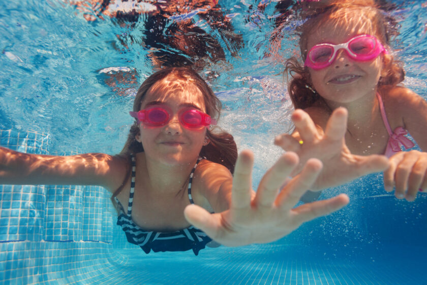 Niñas debajo del agua en la piscina